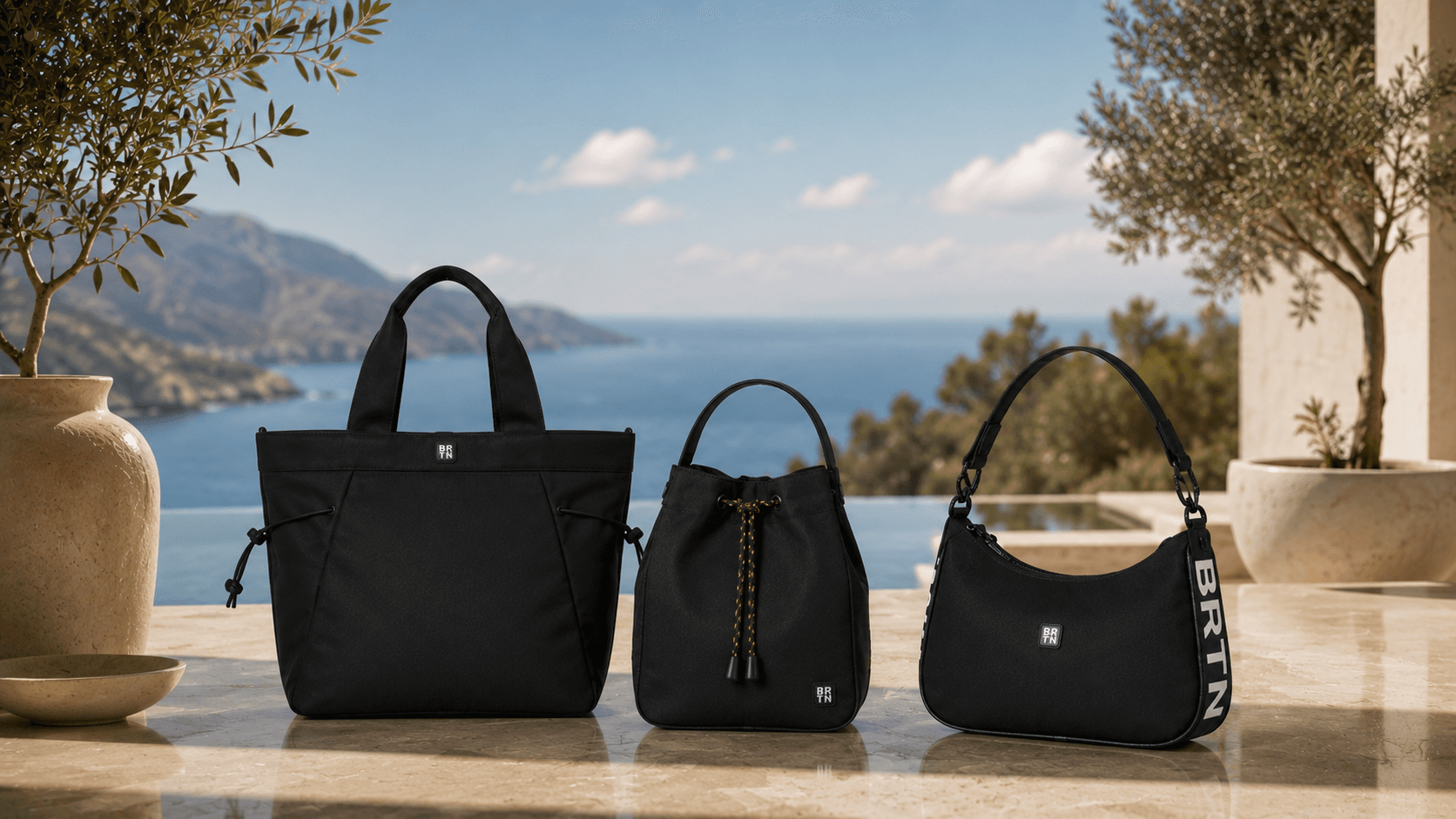 Brighton tote, bucket and hobo bags arranged on a terrace overlooking the Mediterranean coast